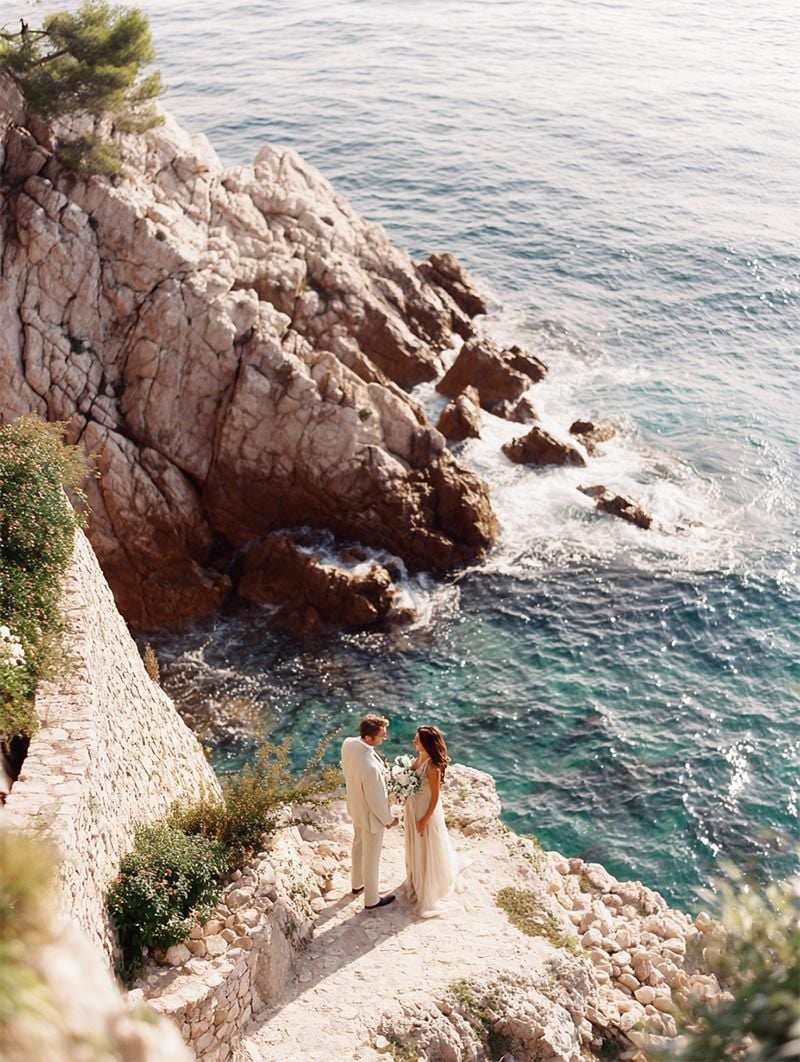 Couple together on a sunlit coastal cliff, Michigan Luxury Weddings engagement collection