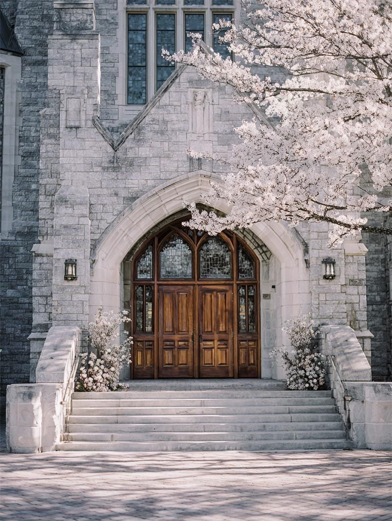 Stone cathedral entrance framed by a cascading floral arch, Michigan luxury wedding ceremony venue