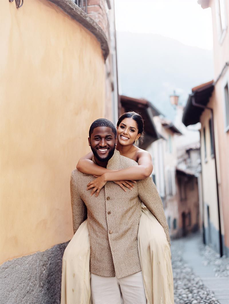 Bride embracing her groom on a sun-washed cobblestone street, editorial luxury wedding portrait by Michigan Luxury Weddings
