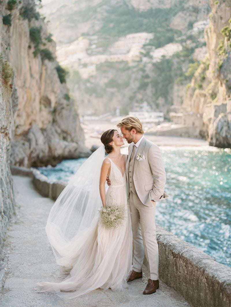 Bride and groom along a coastal walkway in late afternoon light, Michigan Luxury Weddings collection